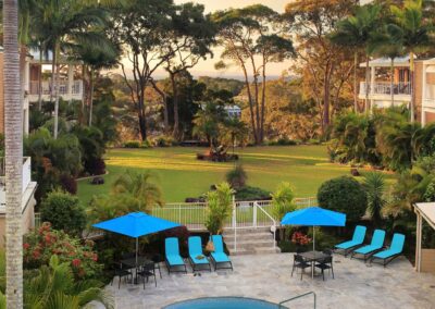 Pool area and spa with umbrellas, sun loungers, and table seating at Serenity Apartments Noosa accommodation